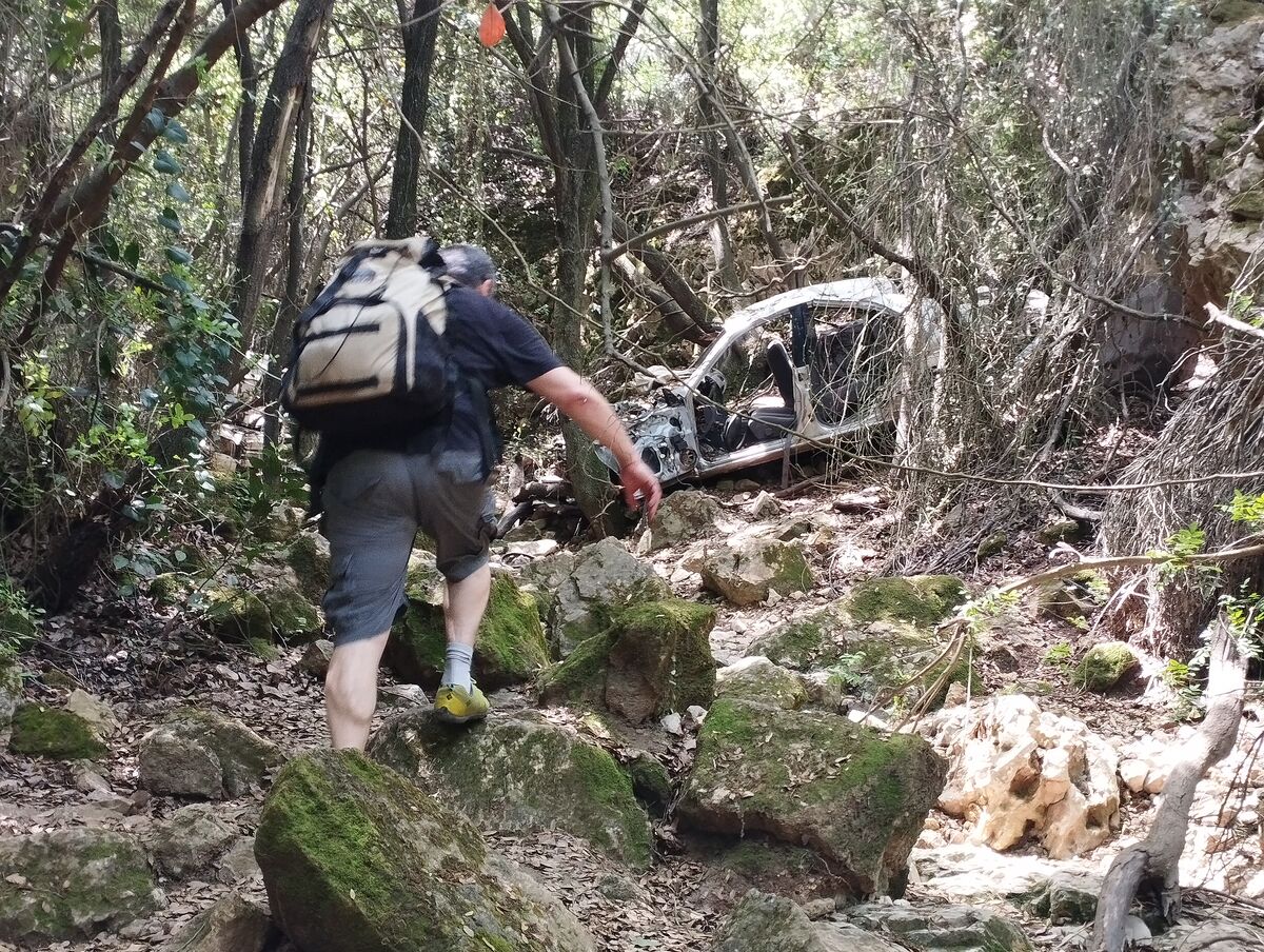 קבוצה הולכת בשביל סלעי עם כוס קפה ביד