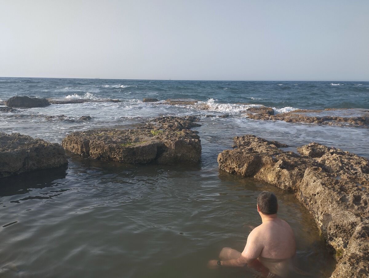 גבר רוחץ בברכת ים סלעית
